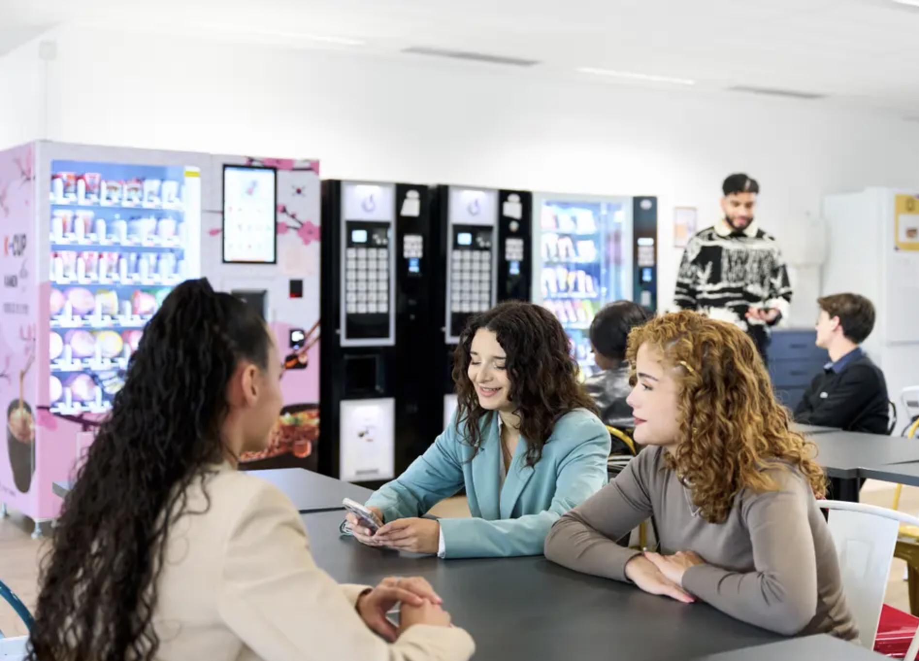 Étudiantes attablées près des distributeurs de la cafétéria