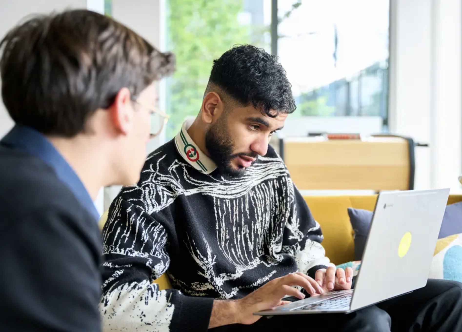 Deux étudiants travaillant ensemble sur un ordinateur portable
